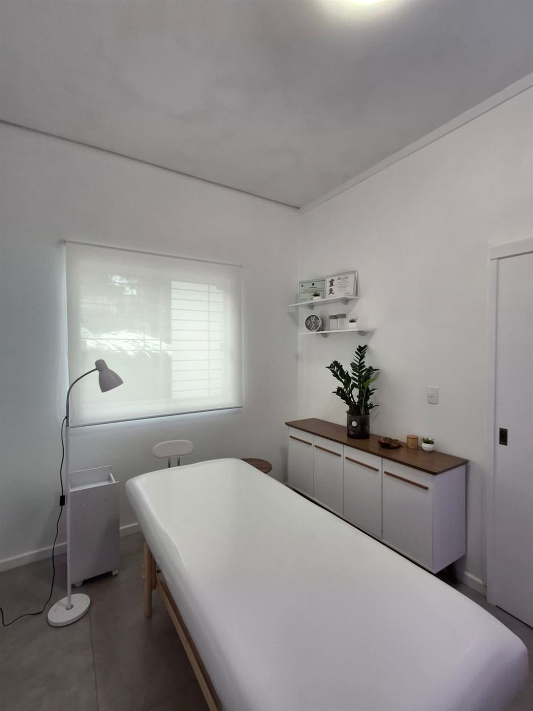 Sala de atendimento da Renata Bucci, com maca branca e luz natural